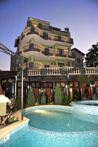 a building with a swimming pool in front of a building at Boryana Hotel in Burgas
