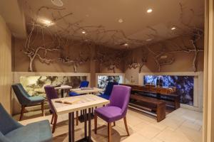 a living room with purple chairs and a piano at Boutique Hotel Capitano in Herceg-Novi