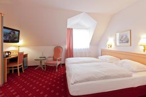 ein Hotelzimmer mit 2 Betten und einem Schreibtisch in der Unterkunft Hotel Für Dich in Waren (Müritz)