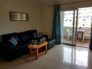 a living room with a couch and a table with a laptop at Apartments in Los Cristianos Centre in Los Cristianos