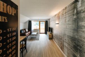 um corredor com uma sala de estar com uma parede em Moderne 3 Zi-FeWo "Industrial Style" 70 qm Naehe Freiburg em Simonswald
