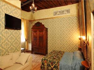 a bedroom with a bed and a couch and a tv at Antica Dimora dell'Orso in Rome