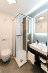 een badkamer met een douche, een toilet en een wastafel bij Moderne 3 Zi-FeWo "Industrial Style" 70 qm Naehe Freiburg in Simonswald