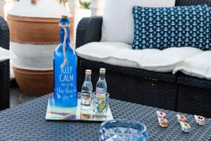 a bottle of water and two glasses on a table at Dimitras Luxus House in Archangelos