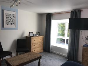 a bedroom with a dresser and a window at Parrett Hotel in South Perrott