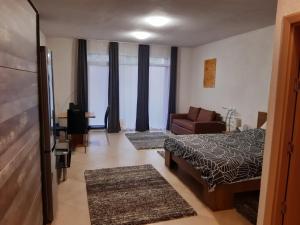 a bedroom with a bed and a couch and a desk at Mira apartman Queen lakosztály in Debrecen