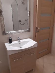 a bathroom with a white sink and a mirror at Mira apartman Queen lakosztály in Debrecen