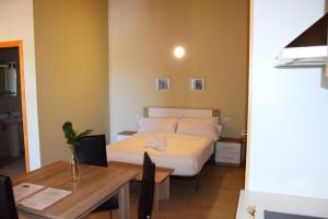 a hotel room with a bed and a table at Apartamentos Giuliano in Empuriabrava