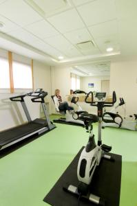 une femme est assise sur un tapis de course dans une salle de sport dans l'établissement Domitys Le Parc Saint Germain, à Montrond-les-Bains