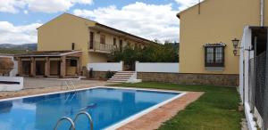 a house with a swimming pool in front of a house at Apartamentos Cortijo los Jacintos in Ronda