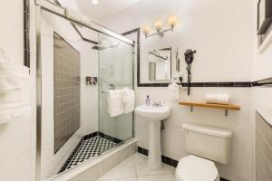 a bathroom with a shower, sink, and toilet at Henry Norman Hotel in Brooklyn