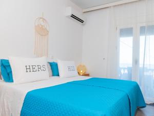 アルハンゲロスにあるDimitras Luxus Houseの窓付きの客室で、青と白のベッド1台を利用できます。