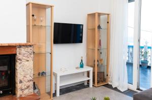 a living room with a tv and a fireplace at Dimitras Luxus House in Archangelos