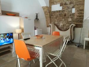 ein Esszimmer mit einem Tisch und Stühlen sowie einem TV in der Unterkunft Borgoantico Apartment in Bari