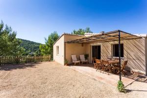 Casa con patio con mesa y sillas en L'Arbre à soleil, en Aigues-Vives