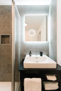 uma casa de banho com um lavatório e um espelho em Moderne 3 Zi-FeWo "Industrial Style" 70 qm Naehe Freiburg em Simonswald