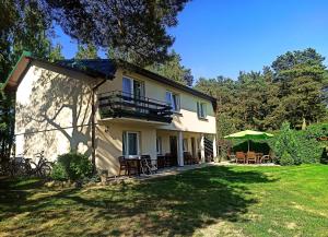 a large house with tables and chairs in the yard at Domki i pokoje "Na szlaku" in Ostrowo