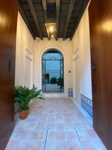 un pasillo vacío con una ventana y una maceta en CASA CASCO HISTÓRICO, en Sevilla