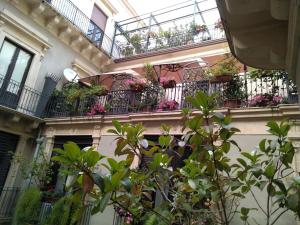 a building with several balconies with flowers on it at House Vintage in Catania