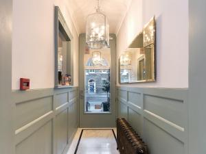 un pasillo con 2 espejos y una ventana en Staunton Hotel - B&B, en Londres