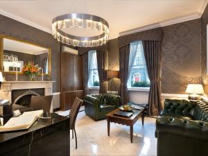 una sala de estar con muebles verdes y una lámpara de araña. en Staunton Hotel - B&B en Londres