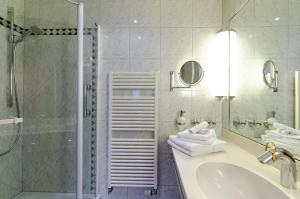 een badkamer met een douche, een wastafel en een bad bij Hotel Gasthof Hecht in Wolfach