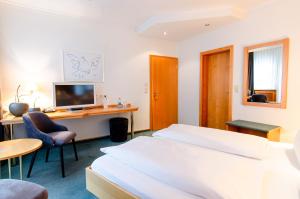 een hotelkamer met een bed en een bureau met een computer bij Hotel Gasthof Hecht in Wolfach