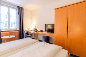 ヴォルフアッハにあるHotel Gasthof Hechtのベッドとデスクが備わるホテルルームです。