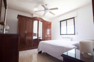 um quarto com uma cama e uma ventoinha de tecto em Finca Los Abetos em Villanueva del Rosario