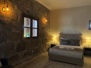 ein Schlafzimmer mit einem Bett mit einer Steinwand in der Unterkunft RURAL HOUSE in Guifões + 79 Fotos