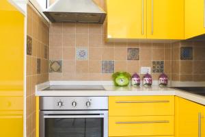 una cucina con armadi gialli e piano cottura di Ai due leoni a Capri