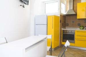una cucina con armadi gialli e frigorifero bianco di Ai due leoni a Capri