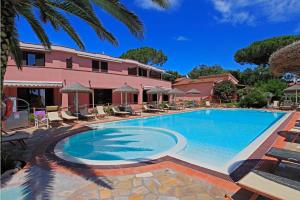 una grande piscina di fronte a una casa rosa di Residence Villa Rosi a Capoliveri