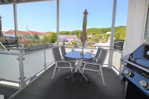 een patio met een tafel en stoelen op een balkon bij Urlaubsdomizil InselLust-Rügen in Sassnitz