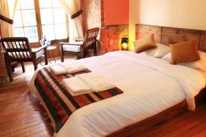 a hotel room with a bed, chair, and nightstand at Patio de Piedra Hotel Boutique in La Paz