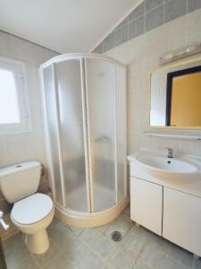 a bathroom with a shower and a toilet and a sink at Sellas Hotel in Sidari