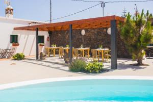 un patio con mesas y sillas junto a un edificio en Casa Volcán y Mar, en Yaiza