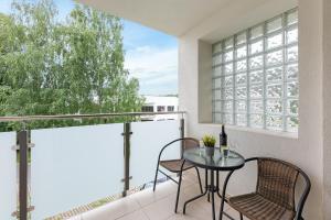 a balcony with a glass table and two chairs at TriApart Amber Jantar III in Jantar