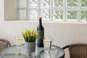 a glass table with a bottle of wine and glasses at TriApart Amber Jantar III in Jantar
