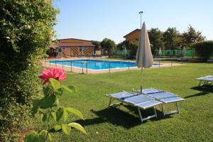 a table with an umbrella next to a pool at Cascina Bosco Gerolo in Rivergaro