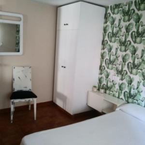 ポルトノボにあるPiso Ubalda Entresueloのベッドルーム1室(ベッド1台、椅子、カーテン付)