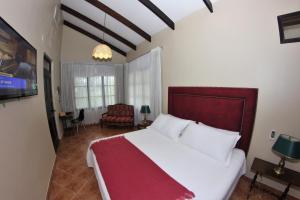 a bedroom with a large white bed and a chair at Fundo San Jose Parque Ecológico & Lodge Hotel Asociado Casa Andina in La Merced