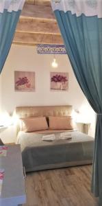a bedroom with a bed with blue curtains at Alghero Old Town Apartment in Alghero
