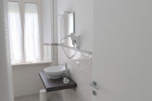 a white bathroom with a sink and a mirror at Amare Sirolo in Sirolo