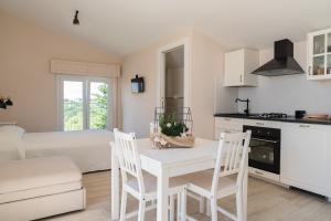 a kitchen and living room with a white table and chairs at Casa Palanca Camere in Sirolo