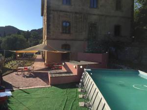 a pool in front of a building with a building with at Student's Hostel Gowett in Campiglia Marittima +47 photos