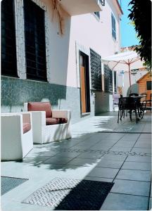 patio z kanapami, stołem i parasolem w obiekcie Casa Ary w mieście Frattamaggiore