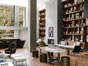 a lobby with a table and chairs and a fireplace at Kimpton Rowan Palm Springs Hotel, an IHG Hotel in Palm Springs