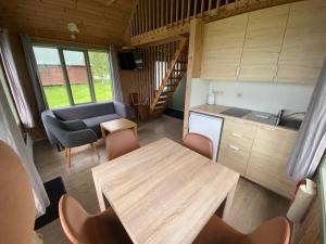 een keuken en een woonkamer met een tafel en een bank bij Hörgsland Cottages in Hörgsland