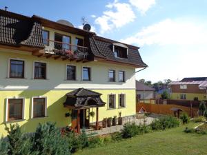 a yellow house with a black roof at Penzion Altendorf in Stará Lesná